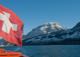 A0372 – Schweizer Fahne und Bänke eines Schiffes rechts, im Hintergrund verschneite Landschaft 